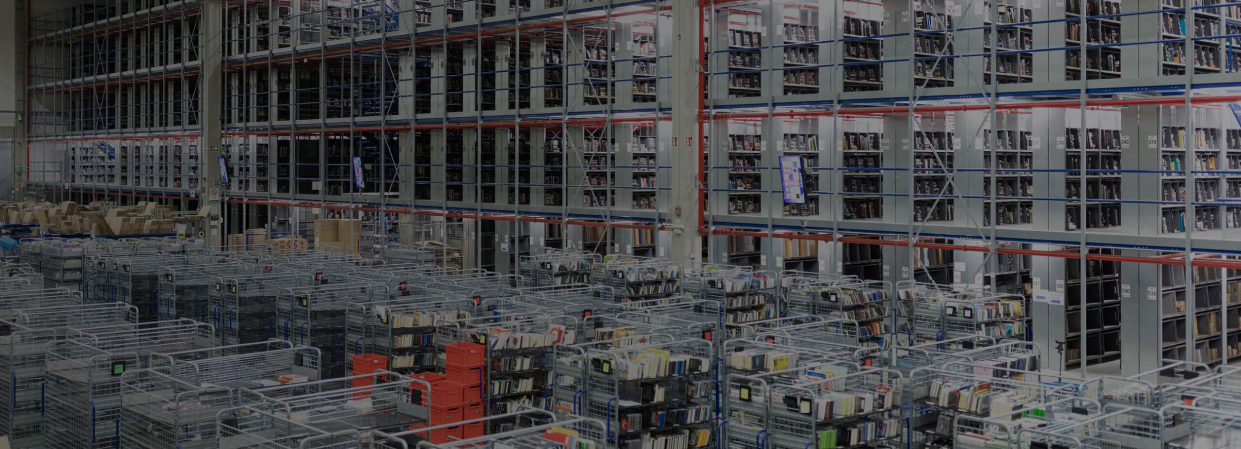 Warehouse showcasing roll pallets and other handling equipment and racking in use.