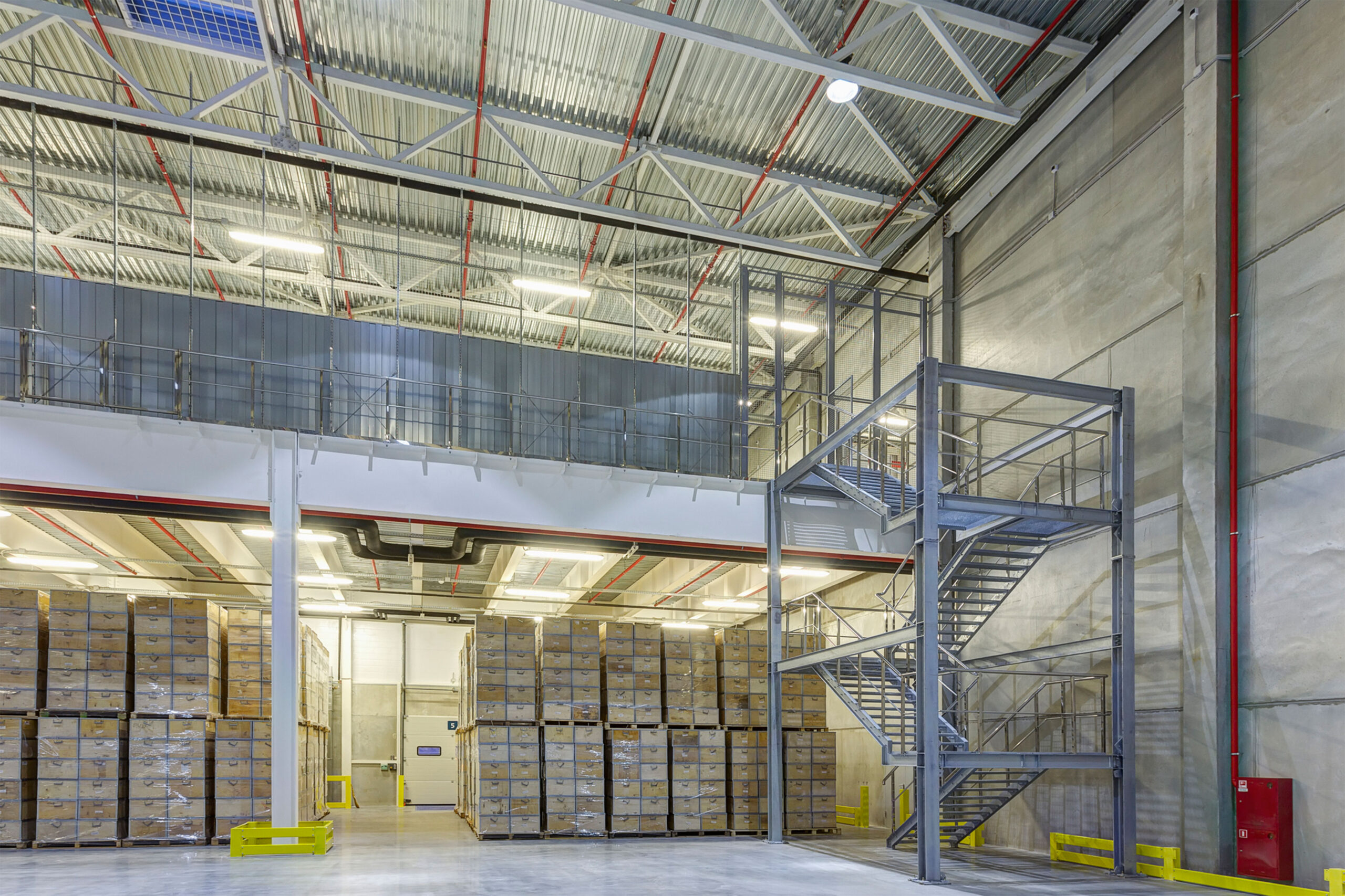 Warehouse with mezzanines and steel staircase and product below.