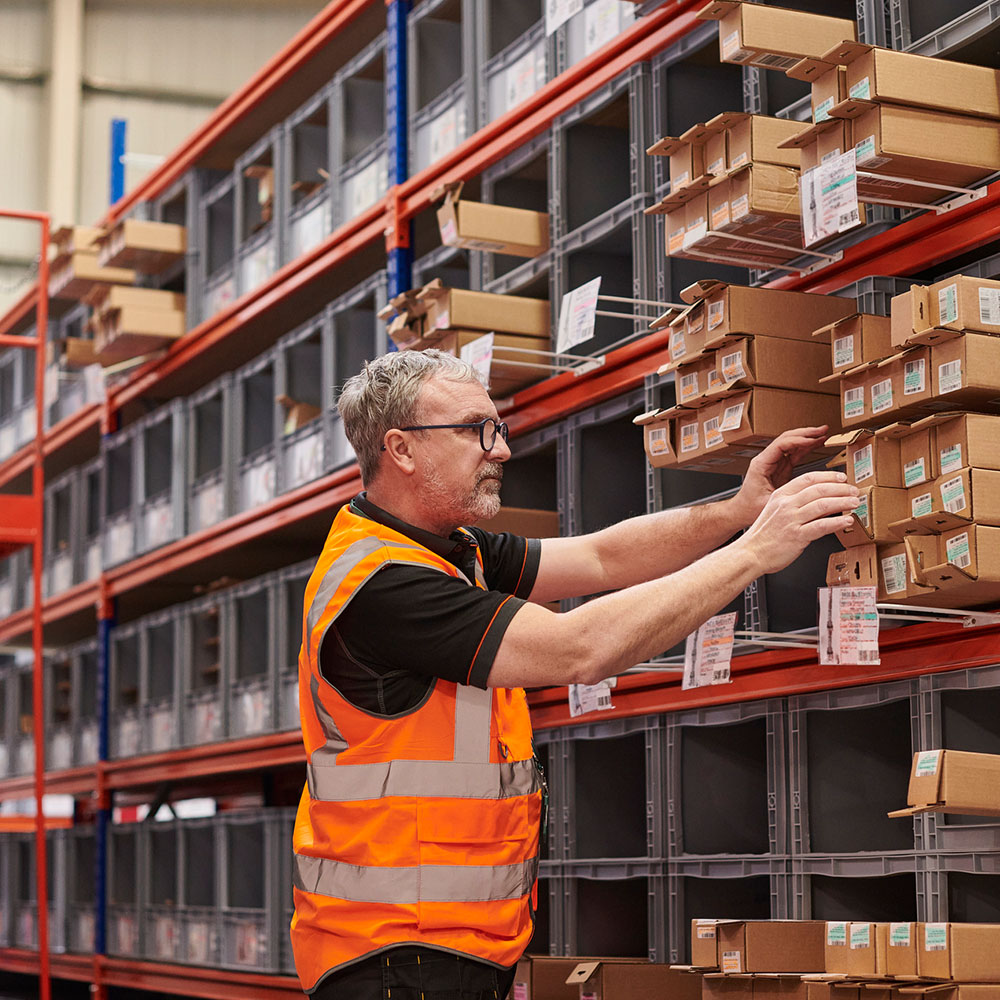 Man walking in warehouse using shelving